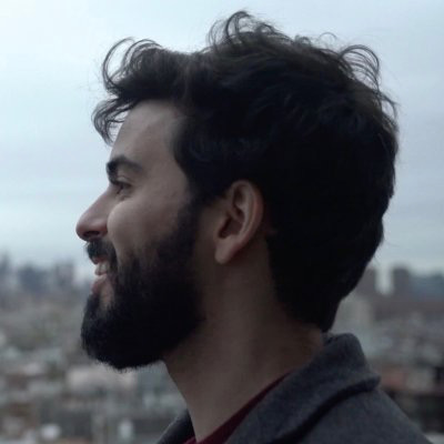 A profile picture of me smiling, a man in his thirties, with dark wavy hair and a dark beard.